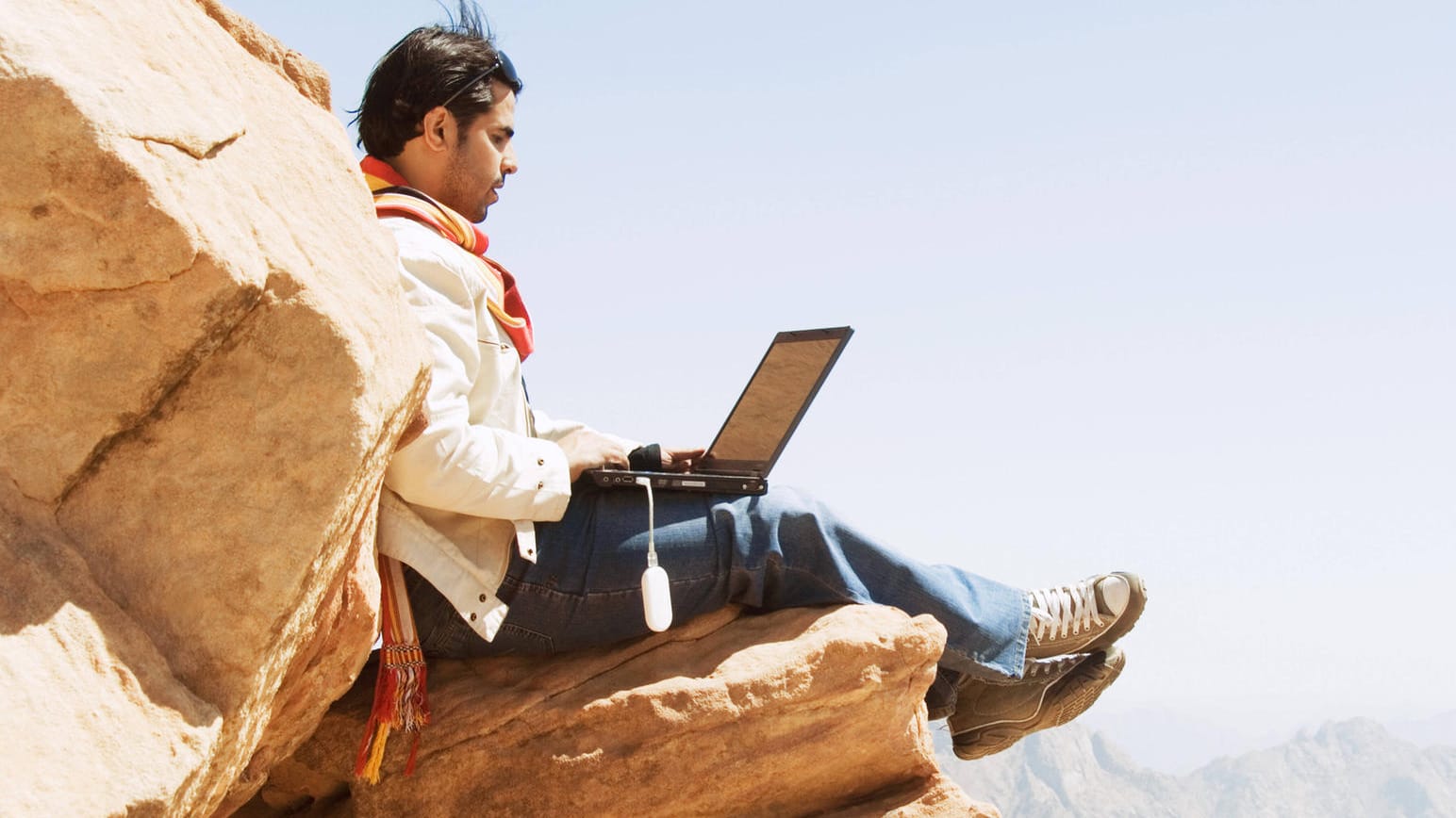 Ein Mann sitzt mit einem Laptop auf einem Felsen: So einfach können Sie davon profitieren, wenn ein Unternehmen einen Teil seines Gewinns ausschüttet. Ein Mann sitzt mit einem Laptop auf einem Felsen: So einfach können Sie davon profitieren, wenn ein Unternehmen einen Teil seines Gewinns ausschüttet.