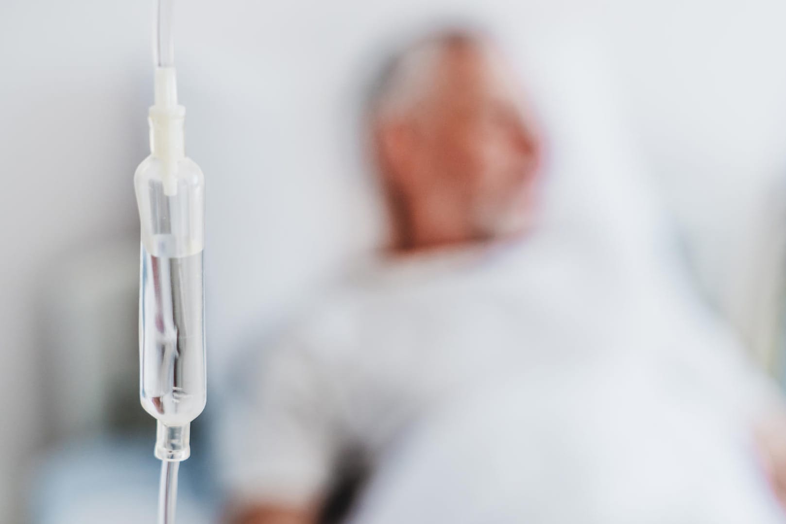 Infusion, im Hintergrund ein älterer Patient Infusion, im Hintergrund ein älterer Patient