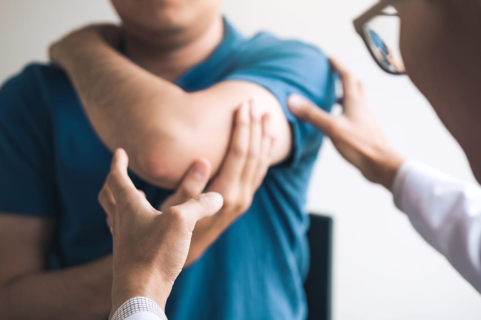 Ein Arzt untersucht den Arm eines Mannes. Ein Arzt untersucht den Arm eines Mannes.