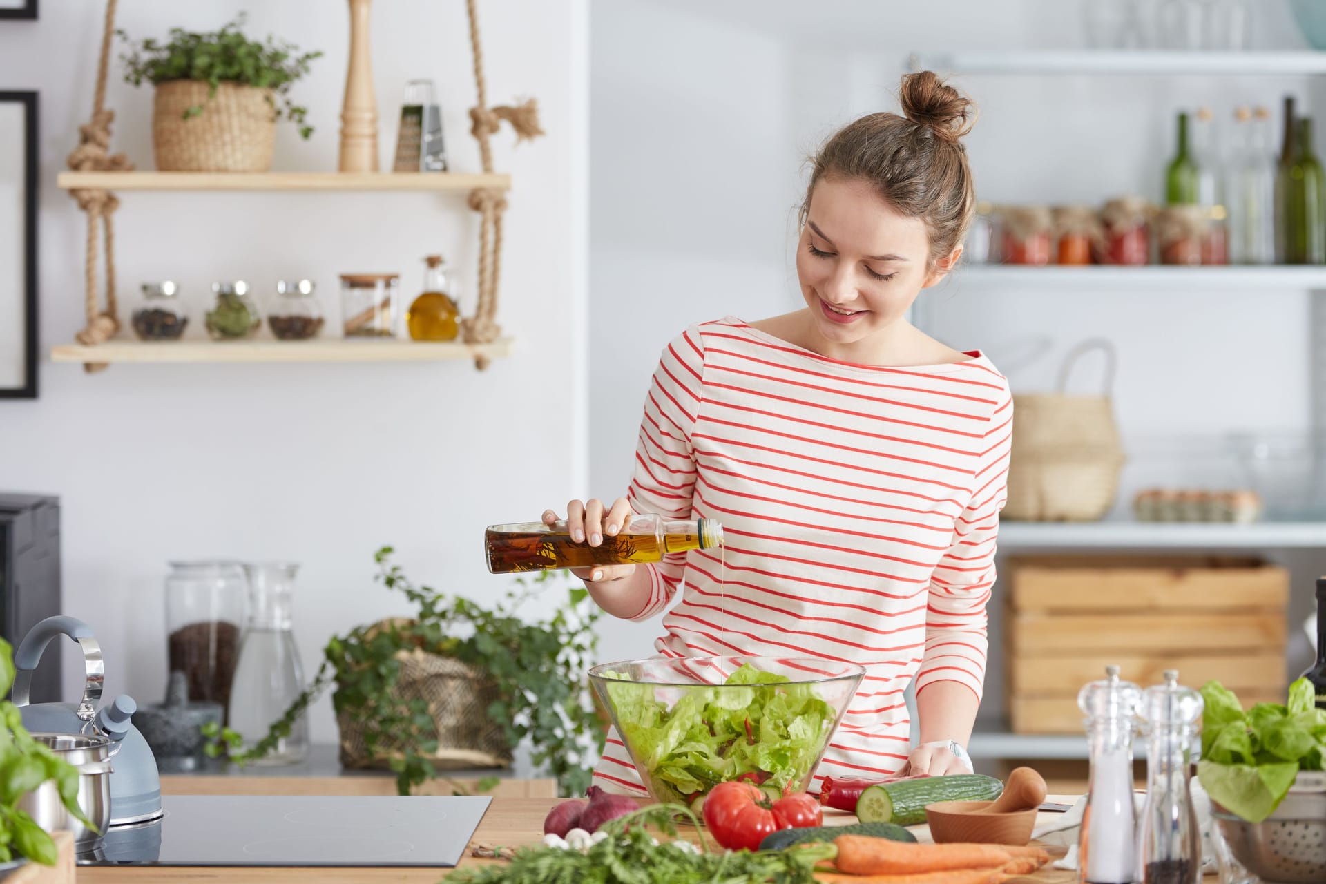 Eine Frau bereitet einen Salat mit Öl zu. Eine Frau bereitet einen Salat mit Öl zu.