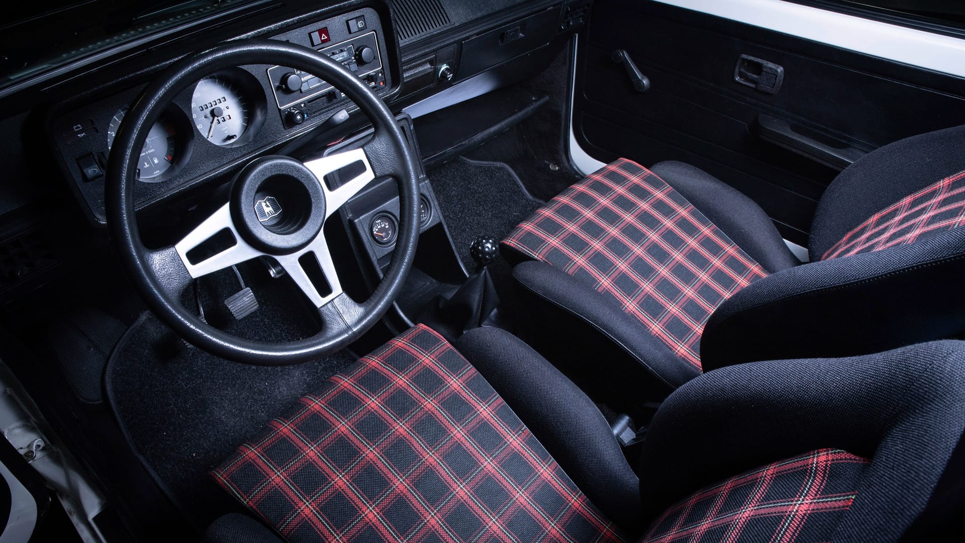 Nur echt mit Karo: Die Sitze des Ur-GTI hatten ein Muster, das in den folgenden Modellgenerationen immer wieder auftauchte. Heute ist es ein Teil des Mythos. Nur echt mit Karo: Die Sitze des Ur-GTI hatten ein Muster, das in den folgenden Modellgenerationen immer wieder auftauchte. Heute ist es ein Teil des Mythos.