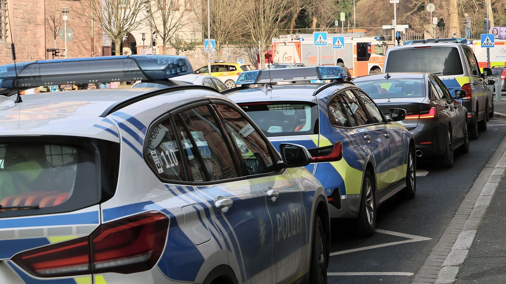 Einige Polizeifahrzeuge und Rettungswagen stehen in der Nähe eines Tatortes in Aschaffenburg: Zwei Menschen wurden getötet, darunter ein Kind. Einige Polizeifahrzeuge und Rettungswagen stehen in der Nähe eines Tatortes in Aschaffenburg: Zwei Menschen wurden getötet, darunter ein Kind.