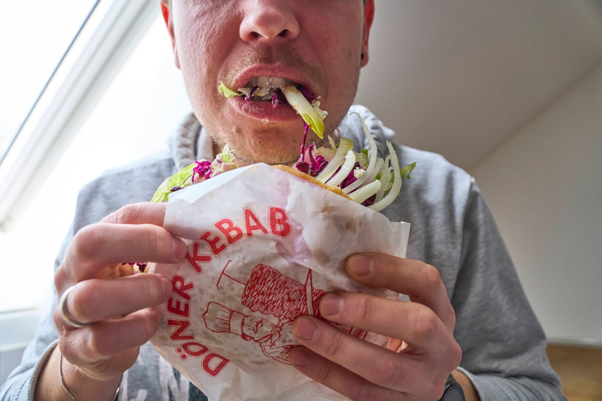 Ein Mann schlingt einen Döner runter: Bei Heißhungerattacken kann schnell ein unangenehmes Völlegefühl entstehen. Ein Mann schlingt einen Döner runter: Bei Heißhungerattacken kann schnell ein unangenehmes Völlegefühl entstehen.