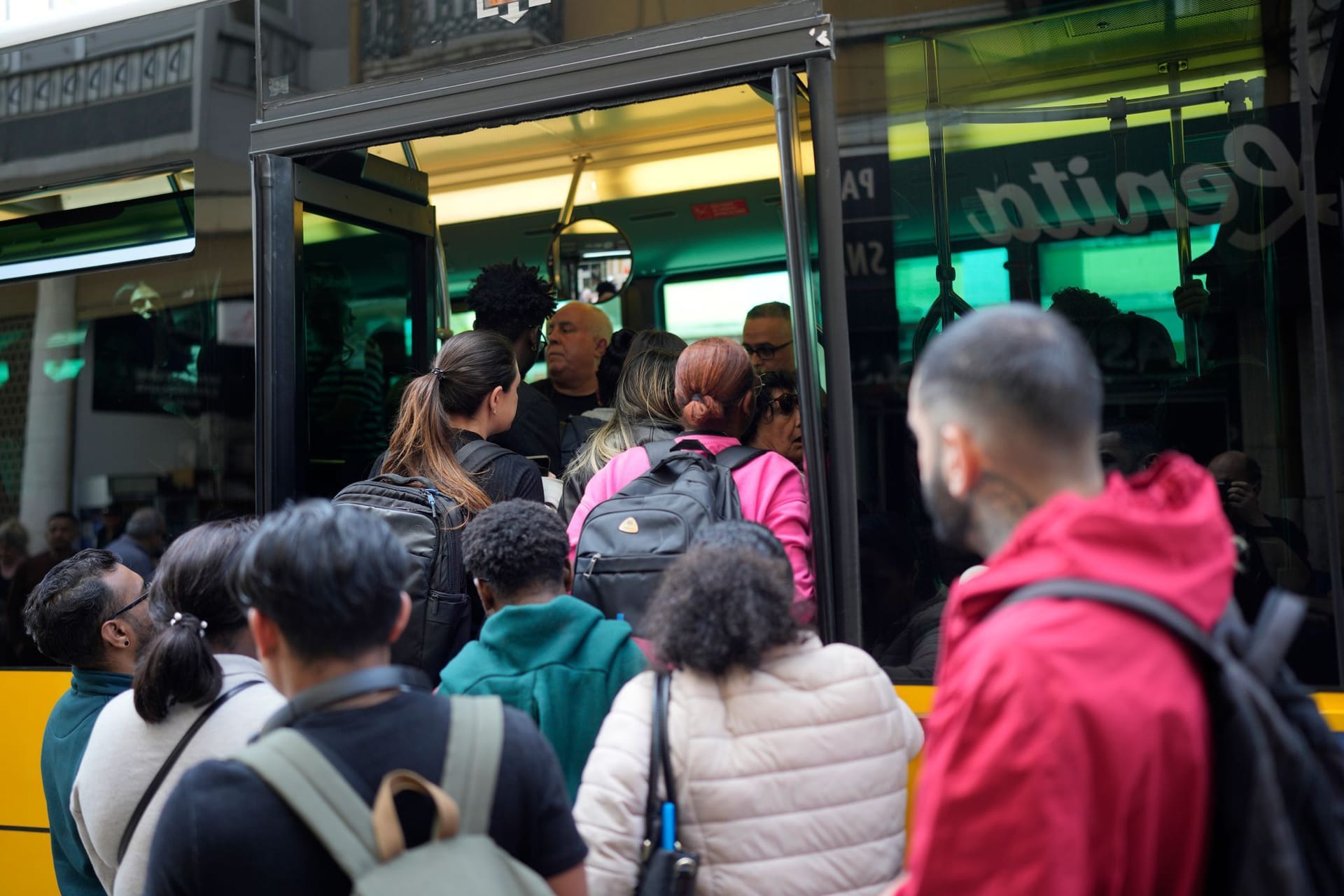Spanier versuchen, einen überfüllten Bus zu besteigen.