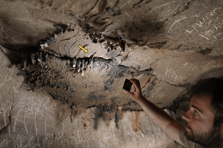 Der Forscher Xabier Garín Artázcoz weist auf die genaue Stelle der Höhle hin: Hier wurde eine römische Münze aus der Zeit des Kaisers Claudius entdeckt